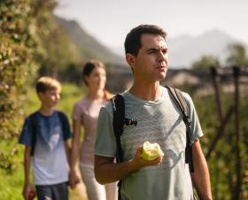 Familia caminando por los manzanos del Tirol del Sur.