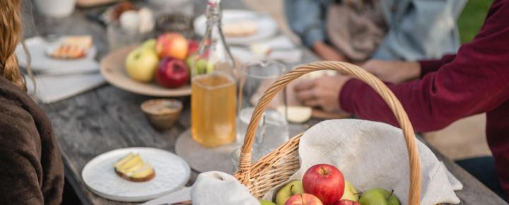 Ein Korb mit Äpfeln am Picknick-Tisch