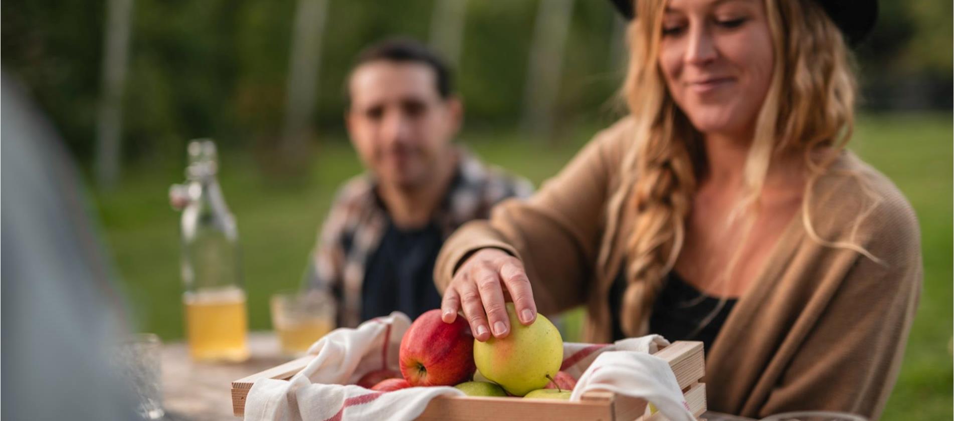 Mädchen nimmt einen Apfel aus einer Kiste